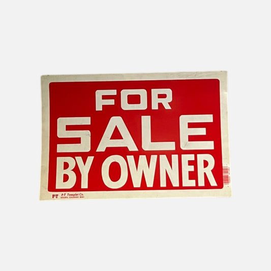 FOR SALE BY OWNER sign, white block letters on a red field inside a white border, creased at the corners, on a white background.
